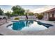 Inviting backyard with a sparkling swimming pool surrounded by lush greenery at 4637 W Misty Willow Ln, Glendale, AZ 85310