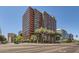 Modern high-rise building with orange accents, palm trees, and a clear blue sky at 4808 N 24Th St # 1003, Phoenix, AZ 85016