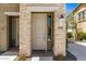 Close-up of the front door with stone pillars, and a modern light fixture, creating a welcoming entrance at 5100 E Rancho Paloma Dr # 2065, Cave Creek, AZ 85331