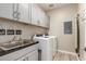 Well-lit laundry room includes modern washer, dryer, and wash basin with gray cabinets for your convenience at 5100 E Rancho Paloma Dr # 2065, Cave Creek, AZ 85331