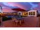 Scenic backyard with covered patio, outdoor dining area, pool, and landscape lighting at sunset at 5228 S 106Th Pl, Mesa, AZ 85212