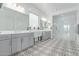 Spa-like bathroom with dual vanities, patterned tile flooring, and glass-enclosed shower at 5228 S 106Th Pl, Mesa, AZ 85212
