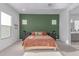 Bright bedroom with a green accent wall, plush carpet, and ensuite bathroom access at 5228 S 106Th Pl, Mesa, AZ 85212
