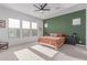 Modern bedroom featuring a green accent wall, neutral carpet, and large windows at 5228 S 106Th Pl, Mesa, AZ 85212