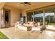Inviting covered patio with cozy seating, a modern fire pit, and sliding glass doors, enhancing indoor-outdoor living at 5228 S 106Th Pl, Mesa, AZ 85212