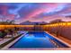 Backyard pool and spa illuminated at dusk, surrounded by desert landscaping and string lights at 5228 S 106Th Pl, Mesa, AZ 85212