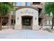 Building 10 entrance featuring a tile roof, stone walls, and lush landscaping at 5450 E Deer Valley Dr # 1195, Phoenix, AZ 85054