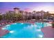 Resort-style pool area with ample seating, lush landscaping, and elegant building facade at dusk at 5450 E Deer Valley Dr # 1195, Phoenix, AZ 85054