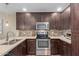 Modern kitchen with stainless steel appliances, rich wood cabinets, mosaic backsplash, and practical U-shaped layout at 5450 E Deer Valley Dr # 1195, Phoenix, AZ 85054