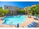 Expansive pool with lounge chairs, umbrellas, and mature shade trees around the property at 5450 E Deer Valley Dr # 1195, Phoenix, AZ 85054
