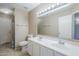 Bathroom featuring double sinks, a large mirror, toilet, and a shower behind a curtain at 5944 W Greenbriar Dr, Glendale, AZ 85308