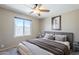 Comfortable bedroom with a ceiling fan, a gray upholstered headboard, and lots of natural light at 5944 W Greenbriar Dr, Glendale, AZ 85308