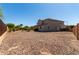 Wide view of backyard featuring low maintenance landscaping, desert plants and turf, and a dark brown fence at 5973 S Legend Dr, Gilbert, AZ 85298