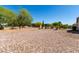 Open backyard featuring a large stone-covered area, privacy wall, and desert landscaping at 5973 S Legend Dr, Gilbert, AZ 85298