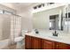 Bright bathroom with dual sinks, dark cabinetry and shower with light colored tile at 5973 S Legend Dr, Gilbert, AZ 85298