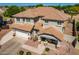 Aerial view of a home with desert landscaping, a front porch, a tile roof, and an attached two-car garage at 5973 S Legend Dr, Gilbert, AZ 85298