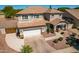 Aerial shot of the home's front exterior, featuring a lush lawn, manicured shrubs, and a two-car garage at 5973 S Legend Dr, Gilbert, AZ 85298