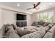 Relaxing living room with a large sectional sofa, plush carpet, and a big screen TV at 5973 S Legend Dr, Gilbert, AZ 85298