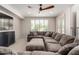 Comfortable seating area with a large sectional sofa, ottoman, ceiling fan, and natural light at 5973 S Legend Dr, Gilbert, AZ 85298