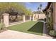 A manicured backyard featuring artificial turf, a decorative wall, and desert landscaping for low-maintenance appeal at 6124 N 31St Ct, Phoenix, AZ 85016