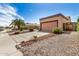 Exterior showing a two-car garage with desert landscaping featuring a light pink garage door at 6203 W Caribe Ln, Glendale, AZ 85306