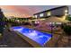 Stunning backyard with a pool, patio, and outdoor seating area, illuminated by string lights at 6449 S Glory Ct, Gilbert, AZ 85298