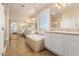 Luxurious bathroom with soaking tub, dual sinks, tiled floors, and sliding glass door shower at 6449 S Glory Ct, Gilbert, AZ 85298