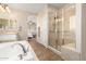 Bathroom featuring a soaking tub with chrome fixtures, tiled shower, and a sink with lots of counter space at 6449 S Glory Ct, Gilbert, AZ 85298