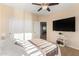 Bright bedroom boasts a ceiling fan, television, and a door to an adjoining room at 6449 S Glory Ct, Gilbert, AZ 85298