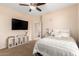 Comfortable bedroom features a ceiling fan, television, and a doorway to an adjoining bathroom at 6449 S Glory Ct, Gilbert, AZ 85298