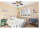 Well-lit bedroom boasts a window with shutters, a ceiling fan, and beach-themed decor at 6449 S Glory Ct, Gilbert, AZ 85298