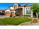 Inviting two-story home featuring a well-manicured lawn, attached three-car garage, and desert landscaping at 6449 S Glory Ct, Gilbert, AZ 85298