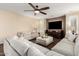 Relaxing living room with a ceiling fan, hardwood floors, a large sectional couch, and a large television at 6449 S Glory Ct, Gilbert, AZ 85298