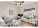 Bright, stylish bedroom with a desk under the window, white daybed and wood flooring at 7185 W Kimberly Way, Glendale, AZ 85308
