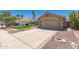Spacious driveway leading to a two-car garage, enhanced by rock and brick landscaping at 7185 W Kimberly Way, Glendale, AZ 85308