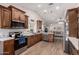Modern kitchen featuring stainless appliances, wood cabinets, a subway tile backsplash, and an open view to the living room at 7185 W Kimberly Way, Glendale, AZ 85308
