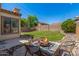Backyard showcasing a fire pit area, green lawn, mature trees, and privacy fencing, ideal for outdoor living at 7236 W Aurora Dr, Glendale, AZ 85308