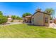 Beautiful backyard showcasing a well-manicured lawn, covered patio, pool, and mature landscaping at 7236 W Aurora Dr, Glendale, AZ 85308
