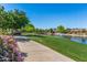 Scenic walking path along a beautiful community pond with a fountain and lush landscaping at 7236 W Aurora Dr, Glendale, AZ 85308