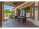 Inviting covered patio featuring comfortable seating, ceiling fan, and views of the landscaped backyard at 7236 W Aurora Dr, Glendale, AZ 85308