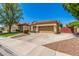 Tan single-story house with mature landscaping, a two-car garage, and a tile roof at 7236 W Aurora Dr, Glendale, AZ 85308