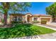 Expansive lush lawn of the single-story house framed by large mature shade trees at 7236 W Aurora Dr, Glendale, AZ 85308