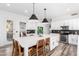 Stylish kitchen featuring a large center island with barstool seating, pendant lighting and stainless steel appliances at 7236 W Aurora Dr, Glendale, AZ 85308