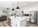 Open-concept kitchen with stainless steel appliances, large island, and seamless flow into the living and patio areas at 7236 W Aurora Dr, Glendale, AZ 85308