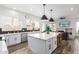 Modern kitchen with white cabinets, stainless steel appliances, large island with barstool seating, and tile backsplash at 7236 W Aurora Dr, Glendale, AZ 85308