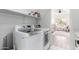 Efficient laundry area with modern washer and dryer units, complemented by ample shelving for storage and organization at 7236 W Aurora Dr, Glendale, AZ 85308