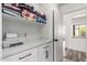 Bright laundry room boasts white cabinetry, sleek quartz countertops, open shelving, and a convenient printer setup at 7236 W Aurora Dr, Glendale, AZ 85308