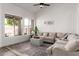Bright living room featuring a large window, high ceilings, and a neutral-colored sectional sofa at 7236 W Aurora Dr, Glendale, AZ 85308