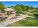 Community playground with a shaded play structure, surrounded by green grass and walking paths at 7236 W Aurora Dr, Glendale, AZ 85308