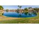 Community pond reflecting nearby homes and palm trees, offering tranquil waterfront scenery at 7236 W Aurora Dr, Glendale, AZ 85308